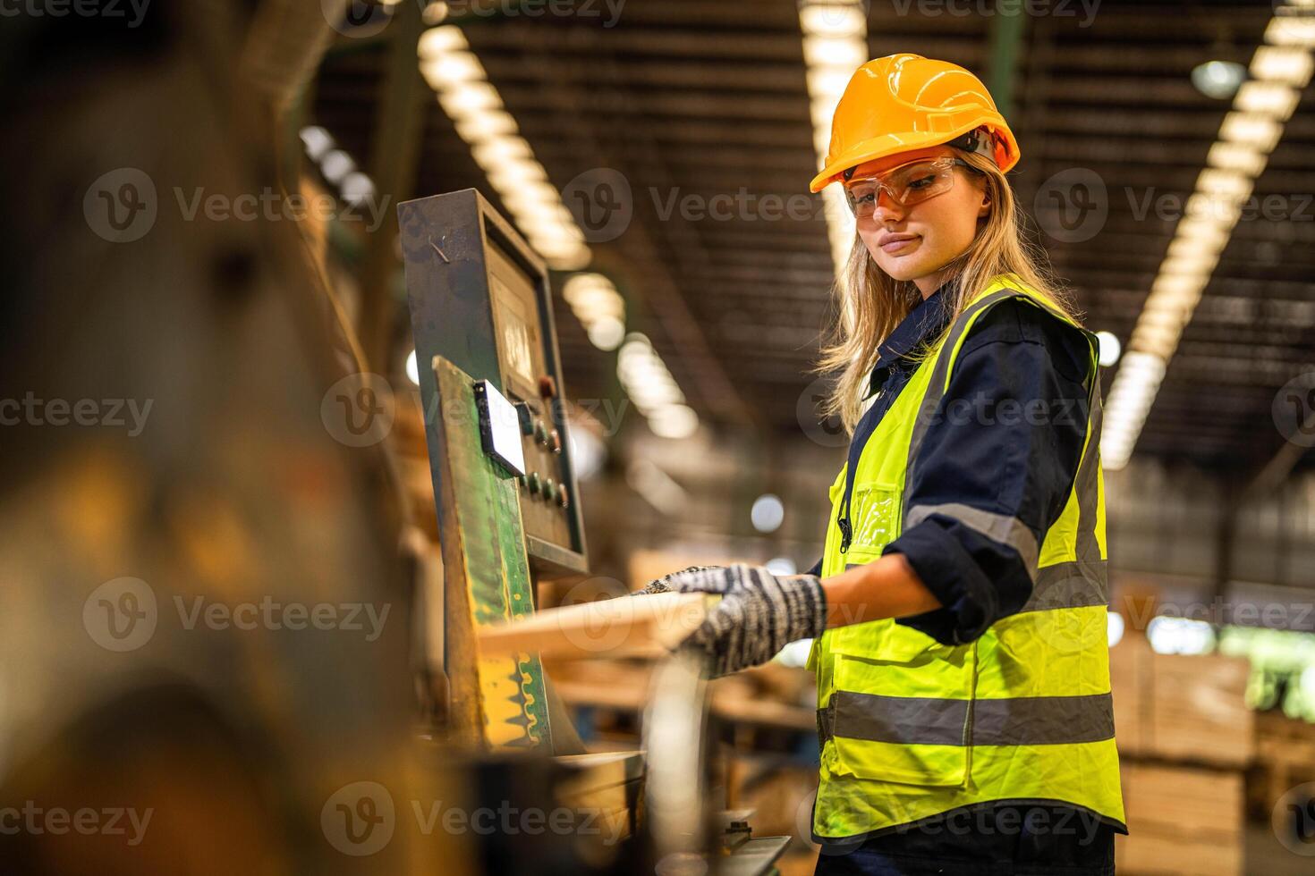 Factory engineer woman standing confident to control panel switch. Worker works at heavy machine at industry factory. worker checking timber of raw wood material. smart industry worker operating. photo