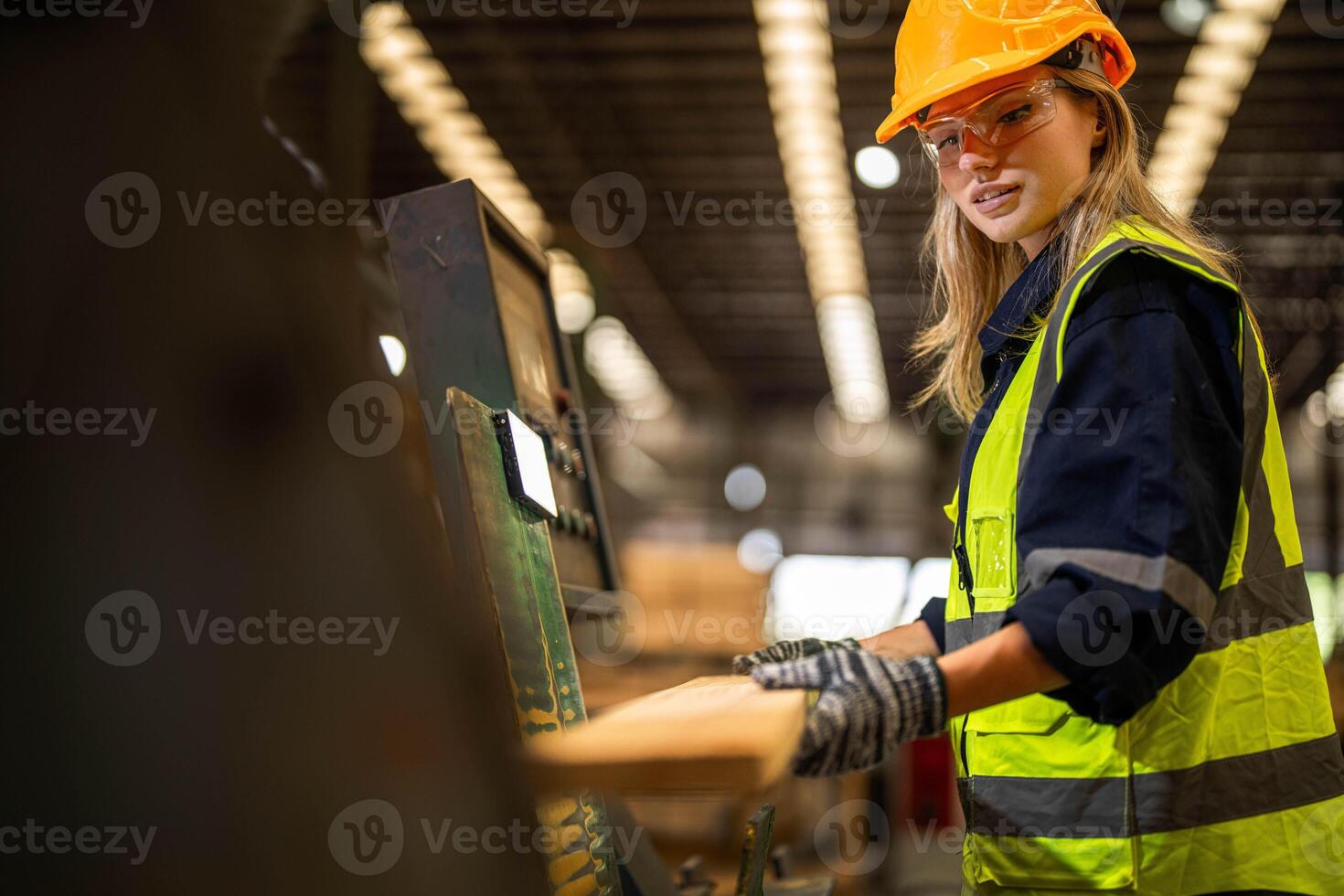Factory engineer woman standing confident to control panel switch. Worker works at heavy machine at industry factory. worker checking timber of raw wood material. smart industry worker operating. photo