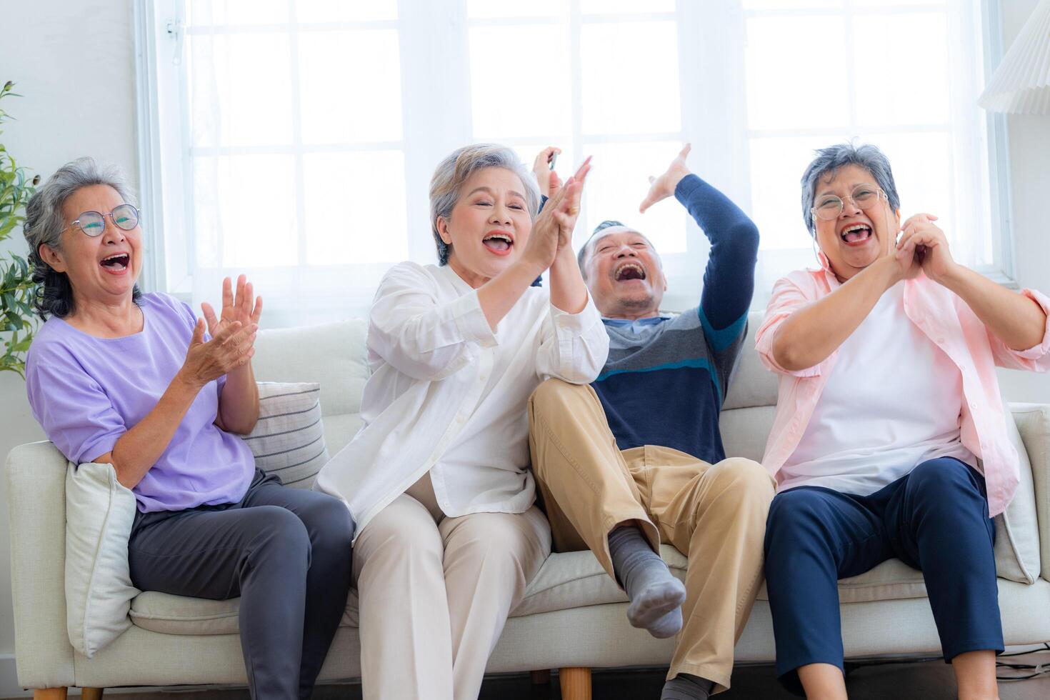 Happiness of the group females and male elderly sitting on the sofa. Senior people are talking and enjoy together at the living room. Joyful carefree retired senior friends enjoying relaxation. photo