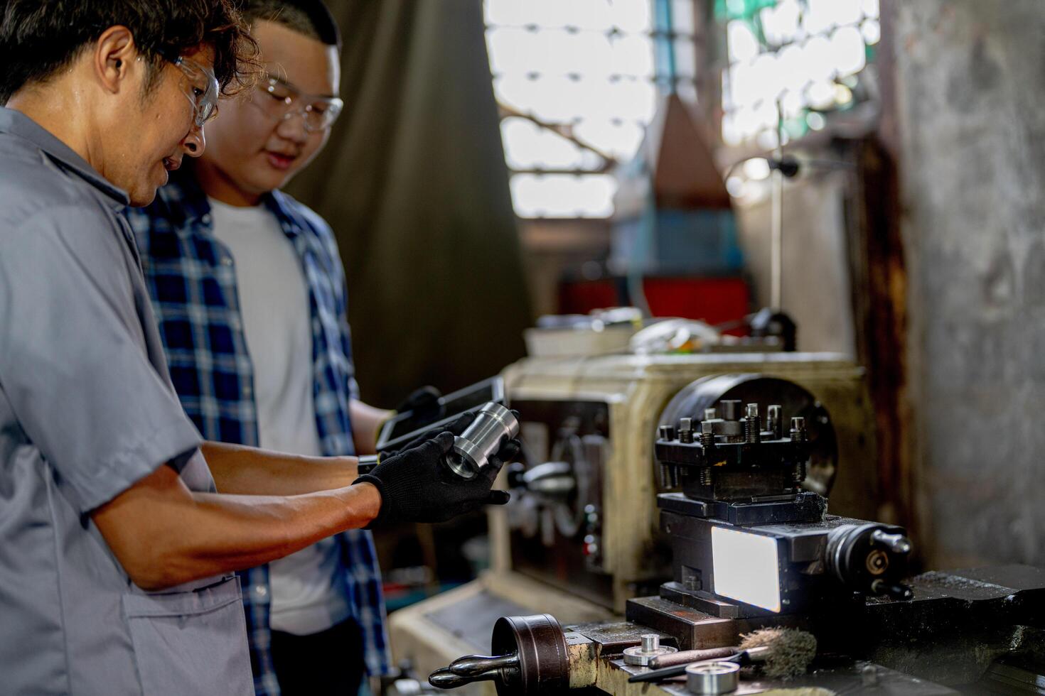 Men are inspecting steel parts for machine installation. team of teacher and student are learning to use heavy machines in steel factory. workers cooperate while doing quality control of manufactured. photo