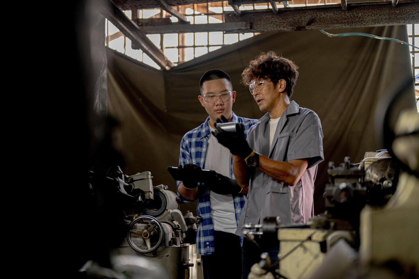 Men are inspecting steel parts for machine installation. team of teacher and student are learning to use heavy machines in steel factory. workers cooperate while doing quality control of manufactured. photo