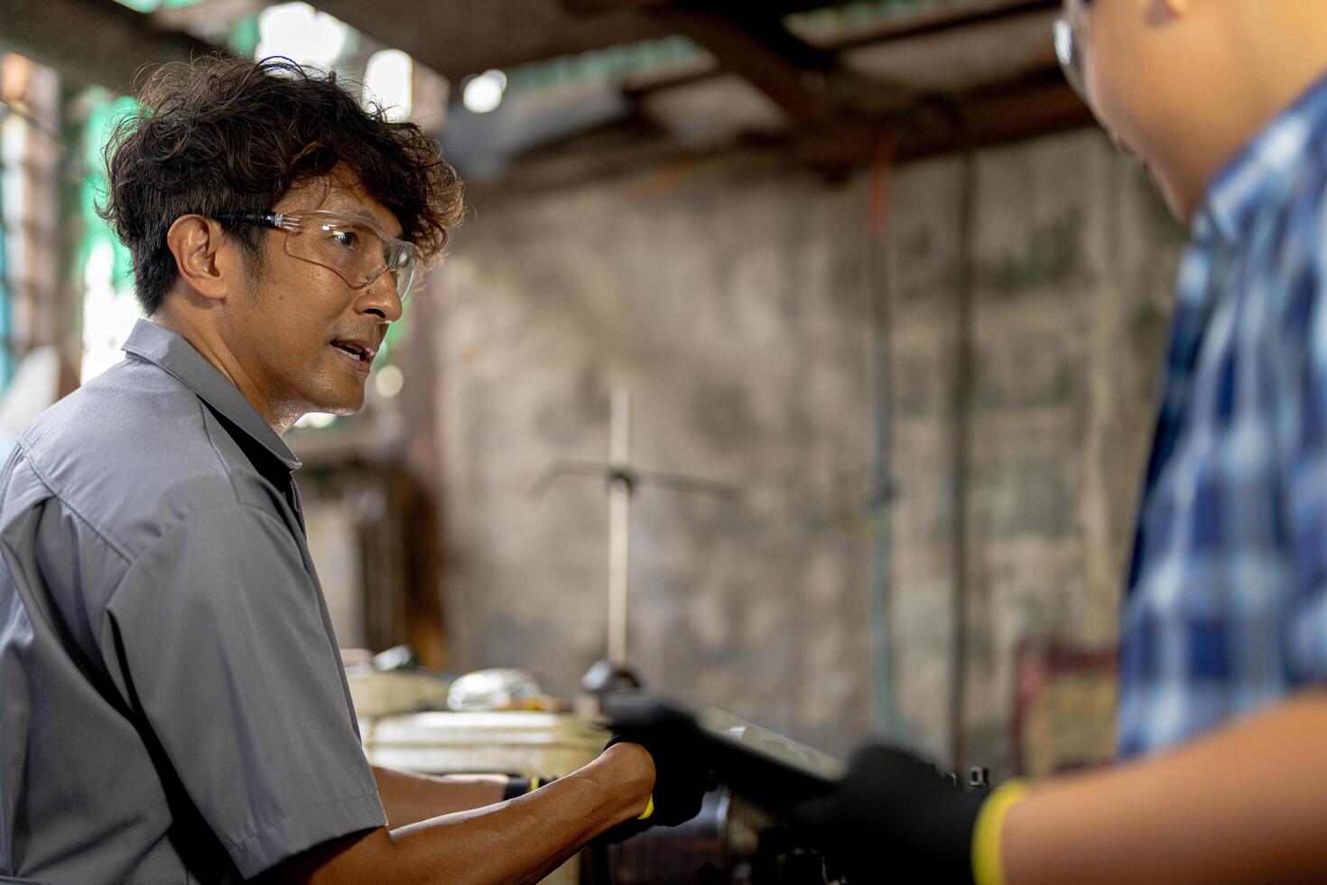 Men are inspecting steel parts for machine installation. team of teacher and student are learning to use heavy machines in steel factory. workers cooperate while doing quality control of manufactured. photo