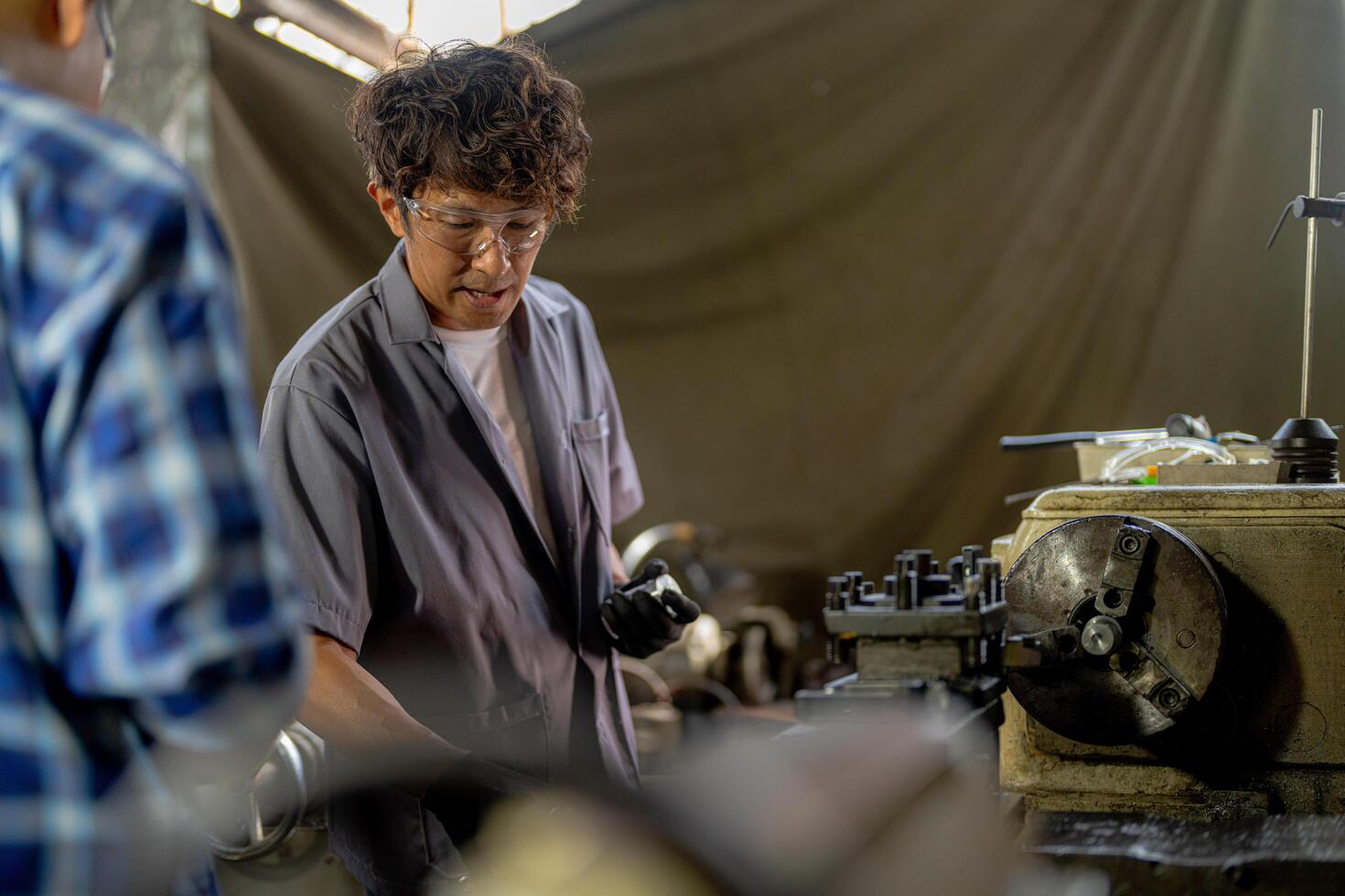 Men are inspecting steel parts for machine installation. team of teacher and student are learning to use heavy machines in steel factory. workers cooperate while doing quality control of manufactured. photo