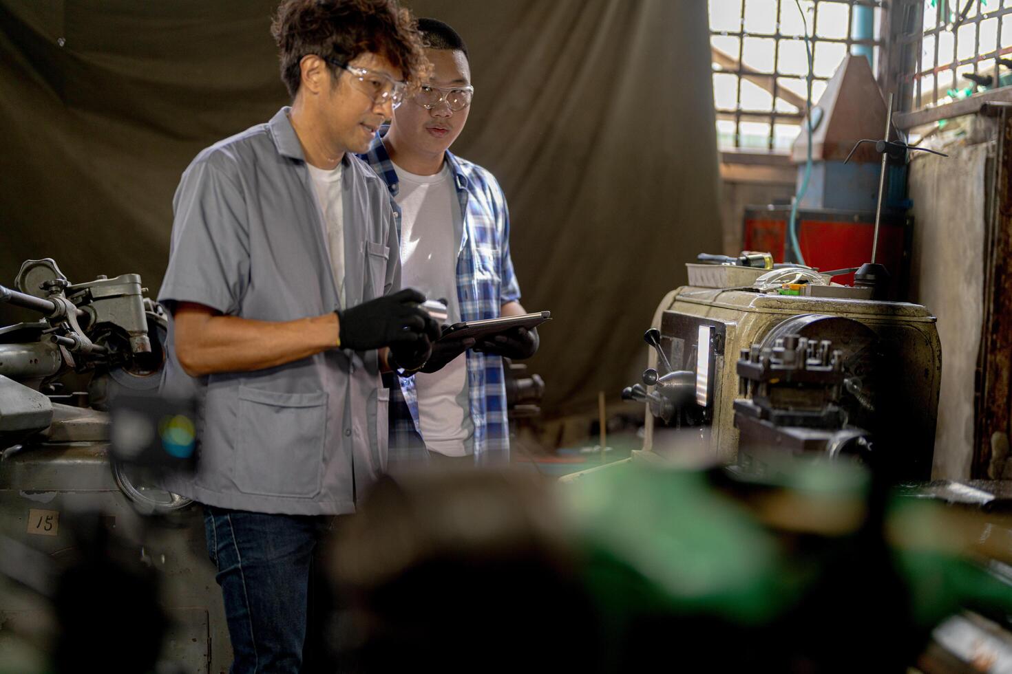 Men are inspecting steel parts for machine installation. team of teacher and student are learning to use heavy machines in steel factory. workers cooperate while doing quality control of manufactured. photo