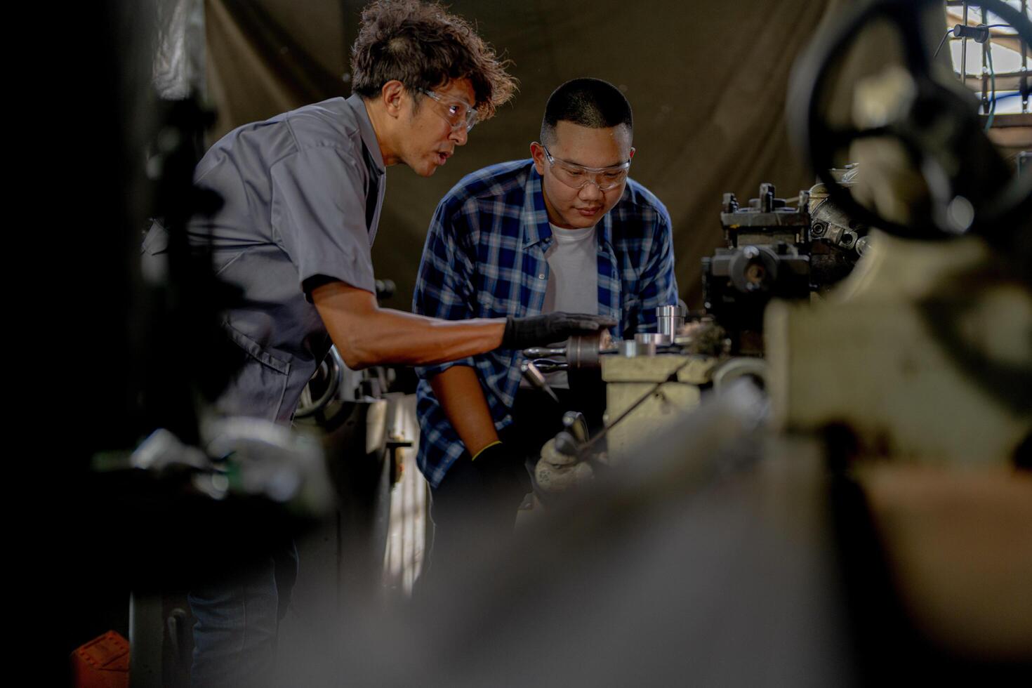 Men are inspecting steel parts for machine installation. team of teacher and student are learning to use heavy machines in steel factory. workers cooperate while doing quality control of manufactured. photo