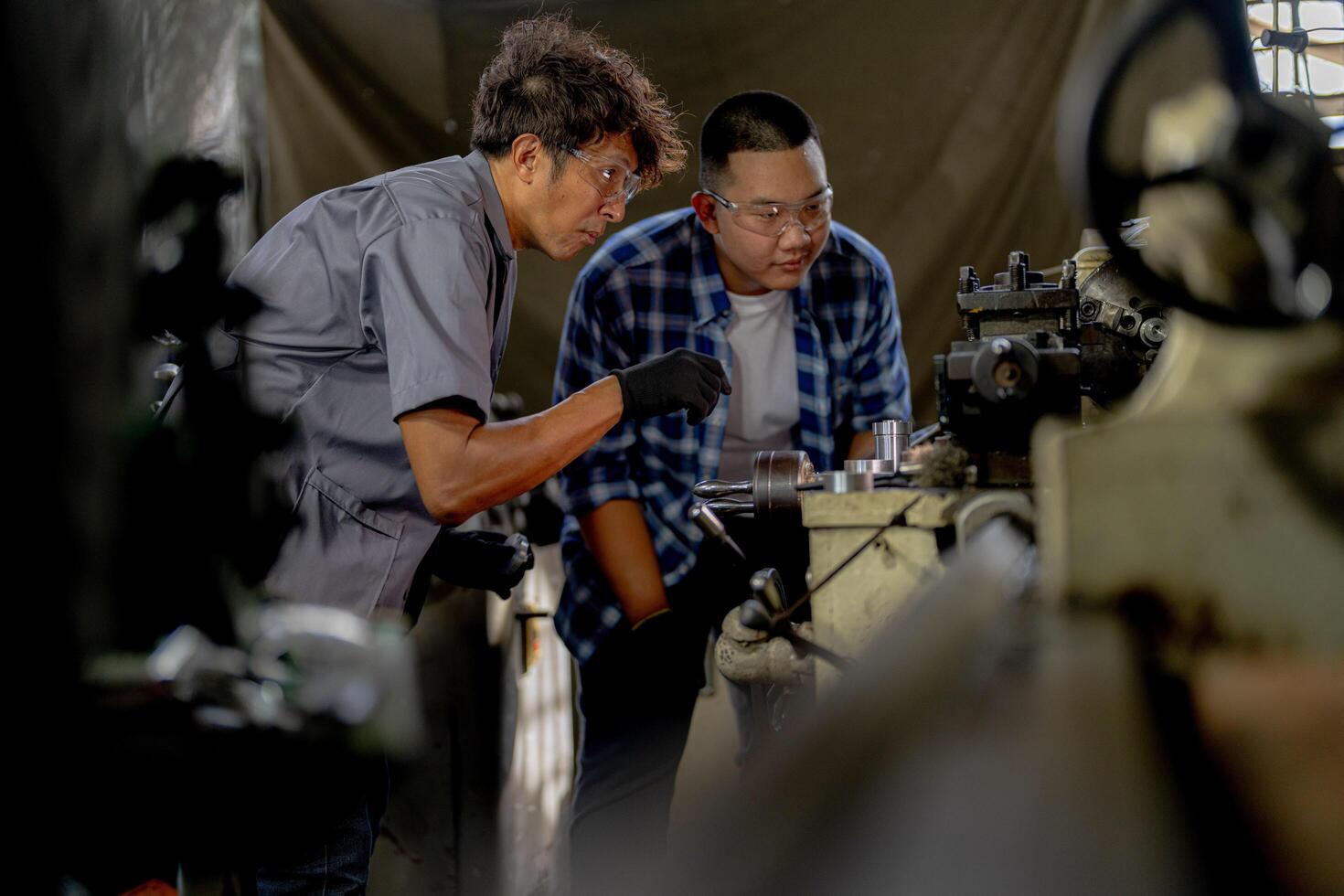 Men are inspecting steel parts for machine installation. team of teacher and student are learning to use heavy machines in steel factory. workers cooperate while doing quality control of manufactured. photo
