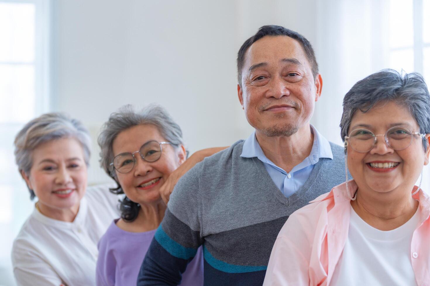 group of asian senior people standing with smart confidence. older people are listening and enjoy meeting focus group at living room. Joyful carefree retired senior friends enjoying relaxation. photo