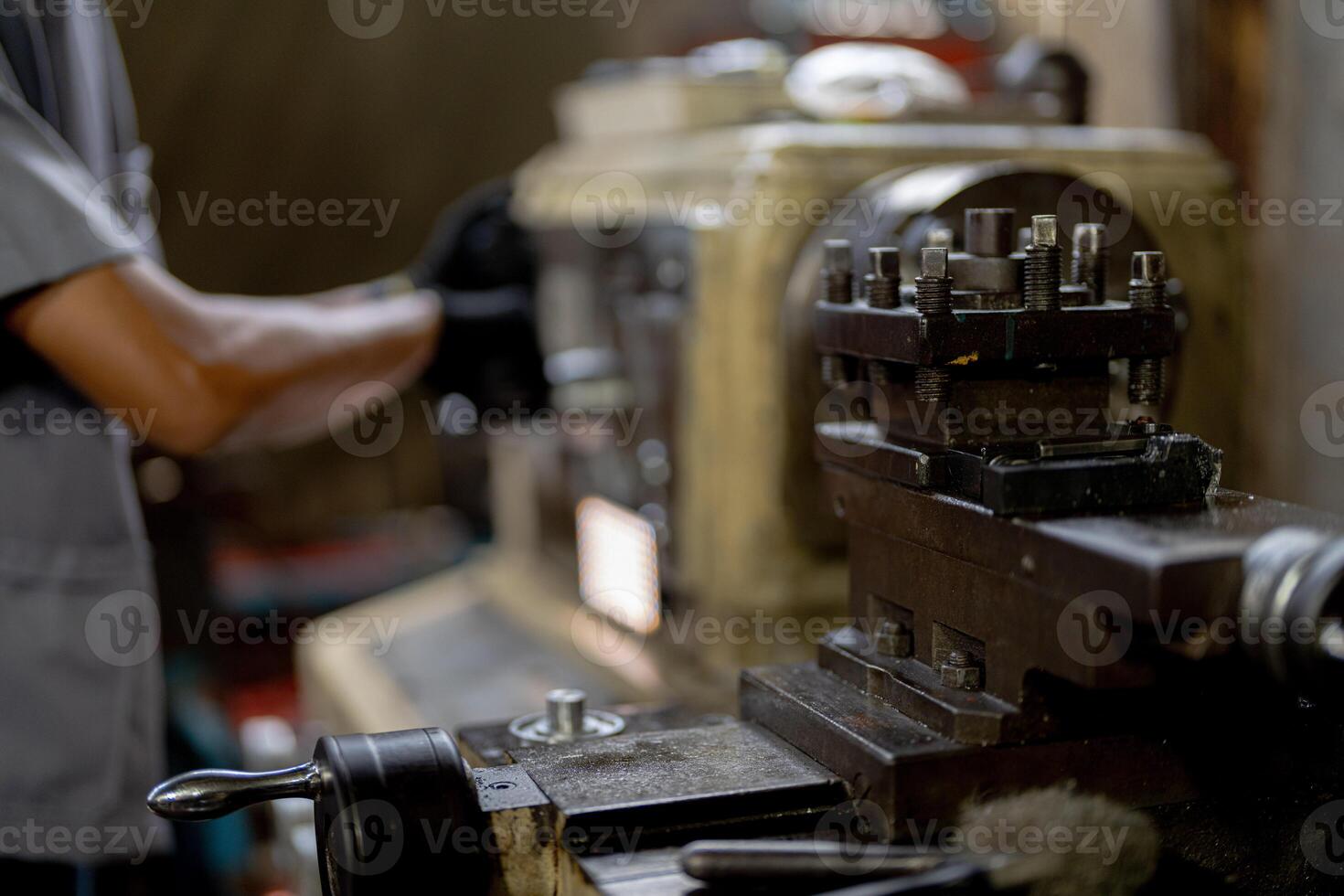 close up hand operation for Metal Lathes. steel column rolling in machine. metalworking industry. worker hand checks mechanic engine. Technician repairing drill bit on metal machine in factory photo
