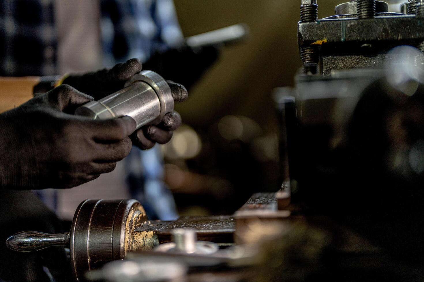 close up hand operation for Metal Lathes. steel column rolling in machine. metalworking industry. worker hand checks mechanic engine. Technician repairing drill bit on metal machine in factory photo