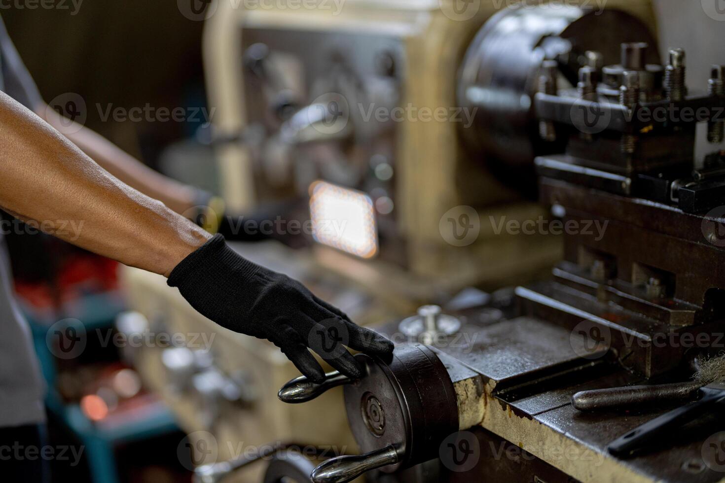 close up hand operation for Metal Lathes. steel column rolling in machine. metalworking industry. worker hand checks mechanic engine. Technician repairing drill bit on metal machine in factory photo