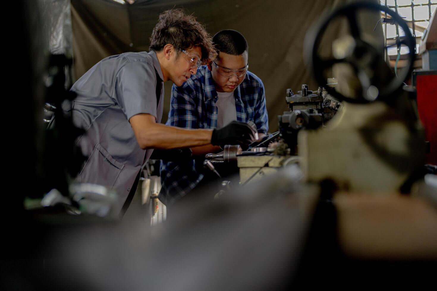 Men are inspecting steel parts for machine installation. team of teacher and student are learning to use heavy machines in steel factory. workers cooperate while doing quality control of manufactured. photo