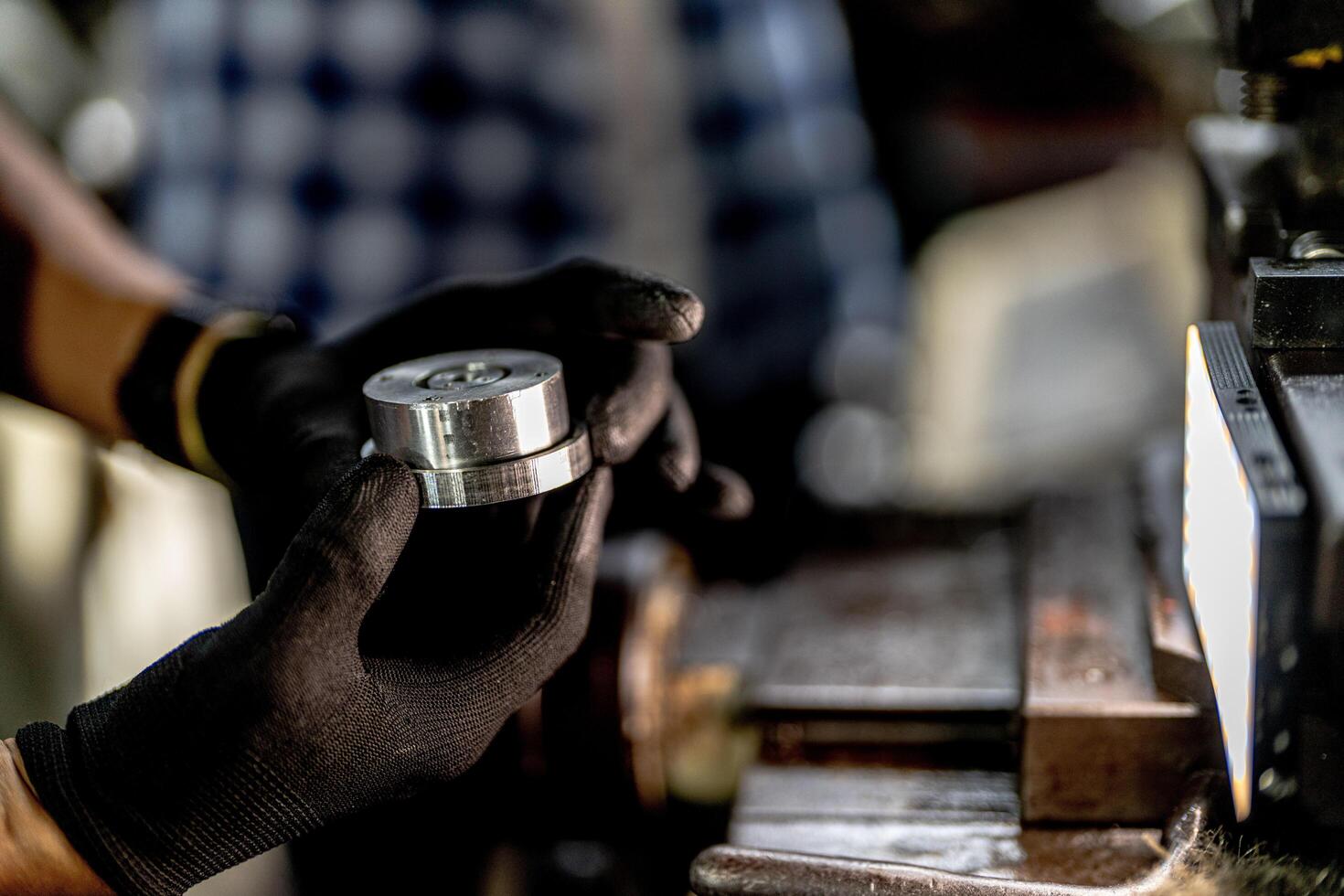 close up hand operation for Metal Lathes. steel column rolling in machine. metalworking industry. worker hand checks mechanic engine. Technician repairing drill bit on metal machine in factory photo
