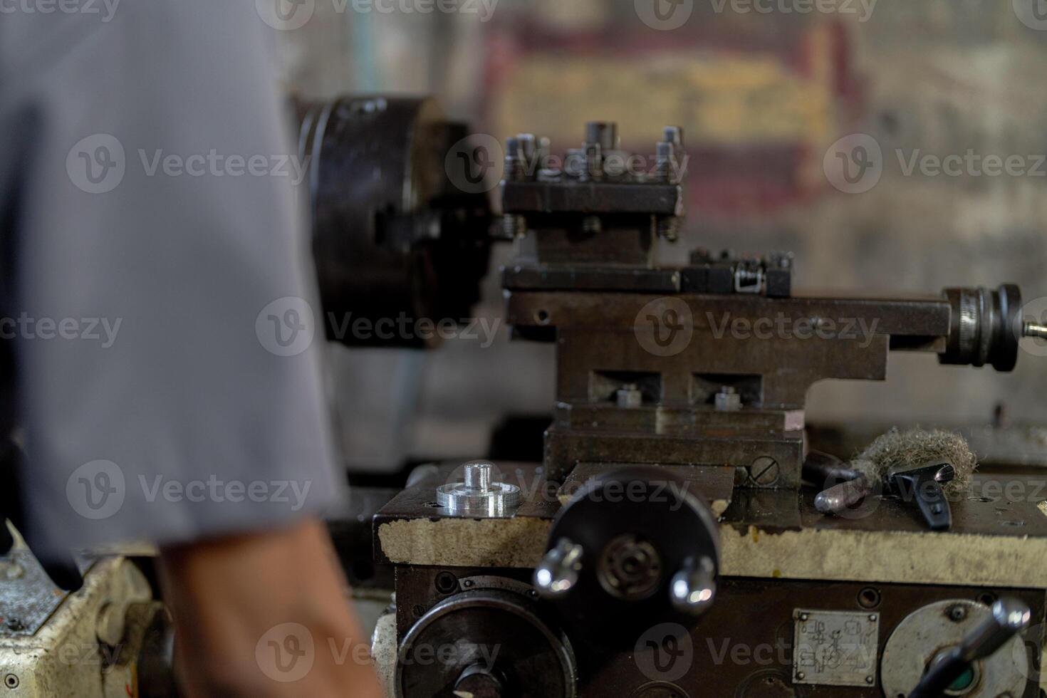 close up hand operation for Metal Lathes. steel column rolling in machine. metalworking industry. worker hand checks mechanic engine. Technician repairing drill bit on metal machine in factory photo