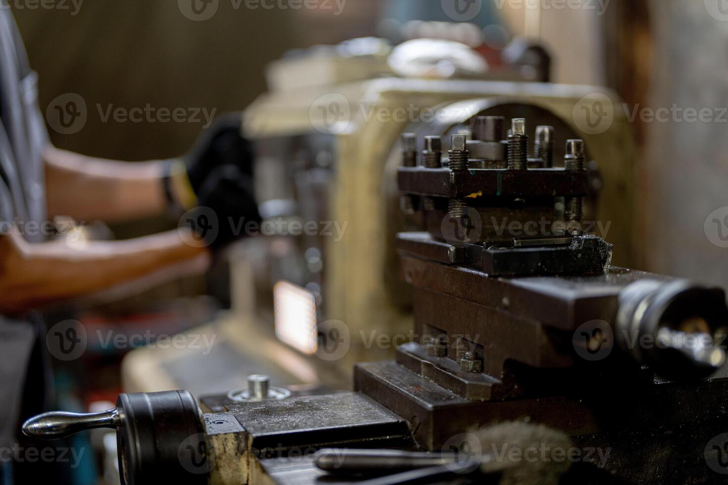 close up hand operation for Metal Lathes. steel column rolling in machine. metalworking industry. worker hand checks mechanic engine. Technician repairing drill bit on metal machine in factory photo