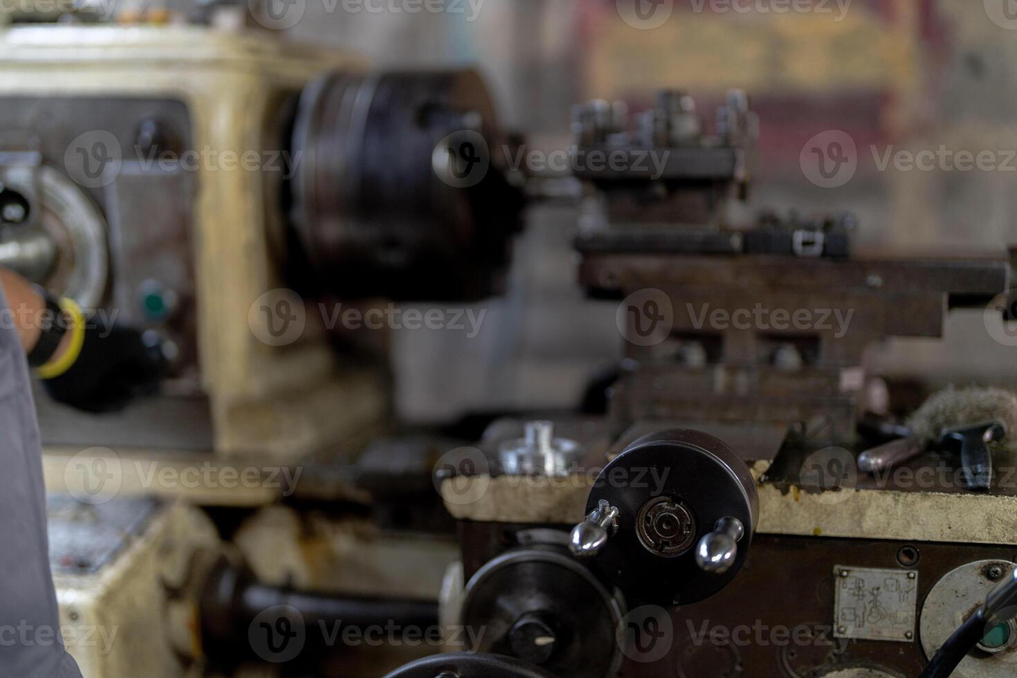 close up hand operation for Metal Lathes. steel column rolling in machine. metalworking industry. worker hand checks mechanic engine. Technician repairing drill bit on metal machine in factory photo
