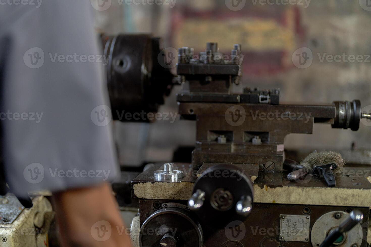 close up hand operation for Metal Lathes. steel column rolling in machine. metalworking industry. worker hand checks mechanic engine. Technician repairing drill bit on metal machine in factory photo