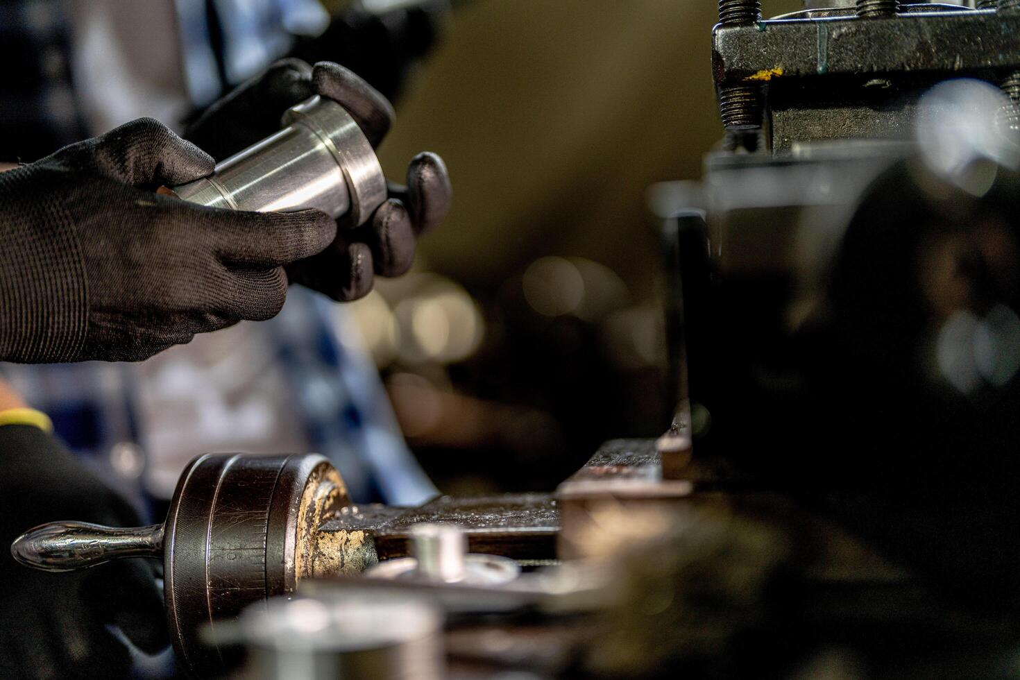 close up hand operation for Metal Lathes. steel column rolling in machine. metalworking industry. worker hand checks mechanic engine. Technician repairing drill bit on metal machine in factory photo