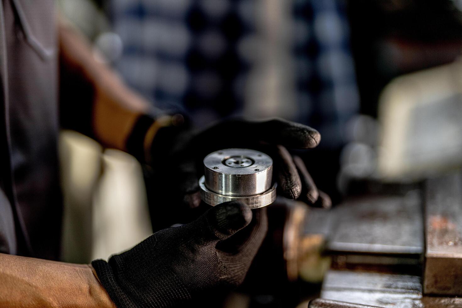 close up hand operation for Metal Lathes. steel column rolling in machine. metalworking industry. worker hand checks mechanic engine. Technician repairing drill bit on metal machine in factory photo