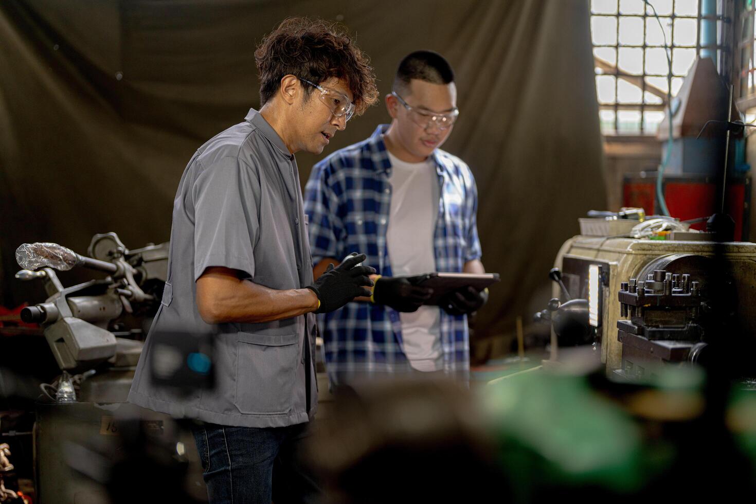 Men are inspecting steel parts for machine installation. team of teacher and student are learning to use heavy machines in steel factory. workers cooperate while doing quality control of manufactured. photo