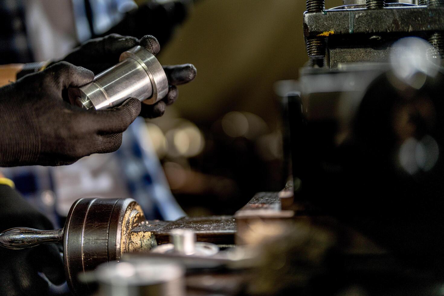close up hand operation for Metal Lathes. steel column rolling in machine. metalworking industry. worker hand checks mechanic engine. Technician repairing drill bit on metal machine in factory photo