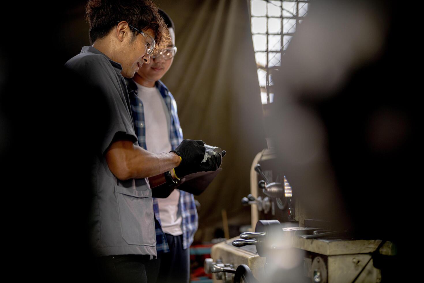 Men are inspecting steel parts for machine installation. team of teacher and student are learning to use heavy machines in steel factory. workers cooperate while doing quality control of manufactured. photo