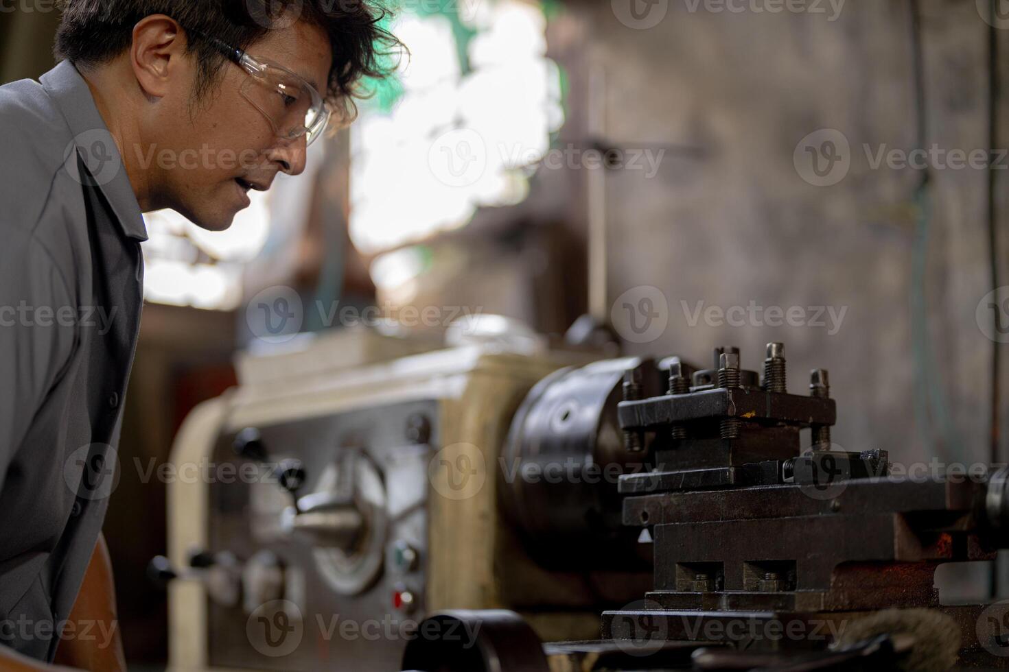 close up operation for Metal Lathes. The steel column rolling in machine. metalworking industry. worker hand checks mechanic engine. Technician repairing drill bit on metal machine in factory photo