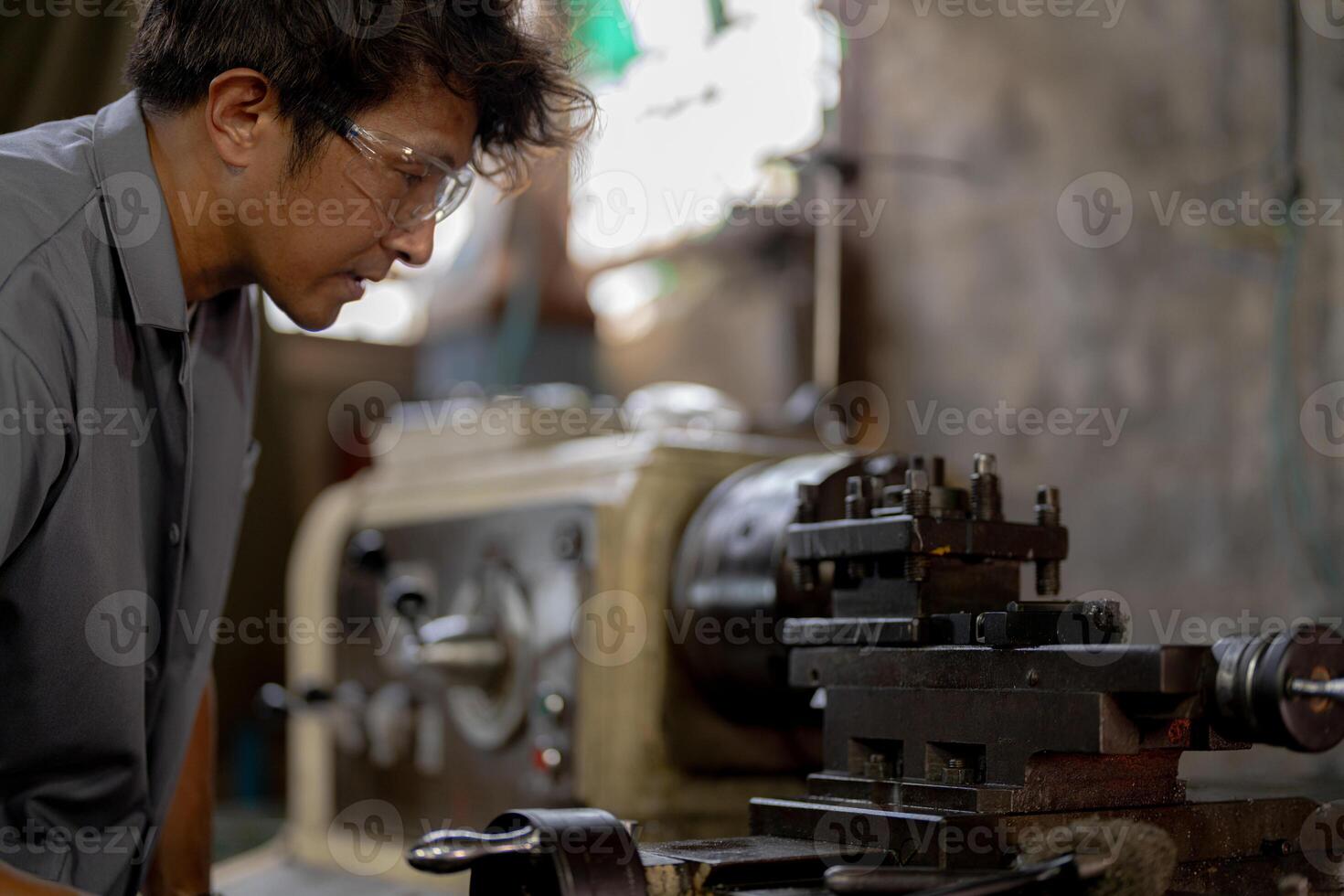 close up operation for Metal Lathes. The steel column rolling in machine. metalworking industry. worker hand checks mechanic engine. Technician repairing drill bit on metal machine in factory photo