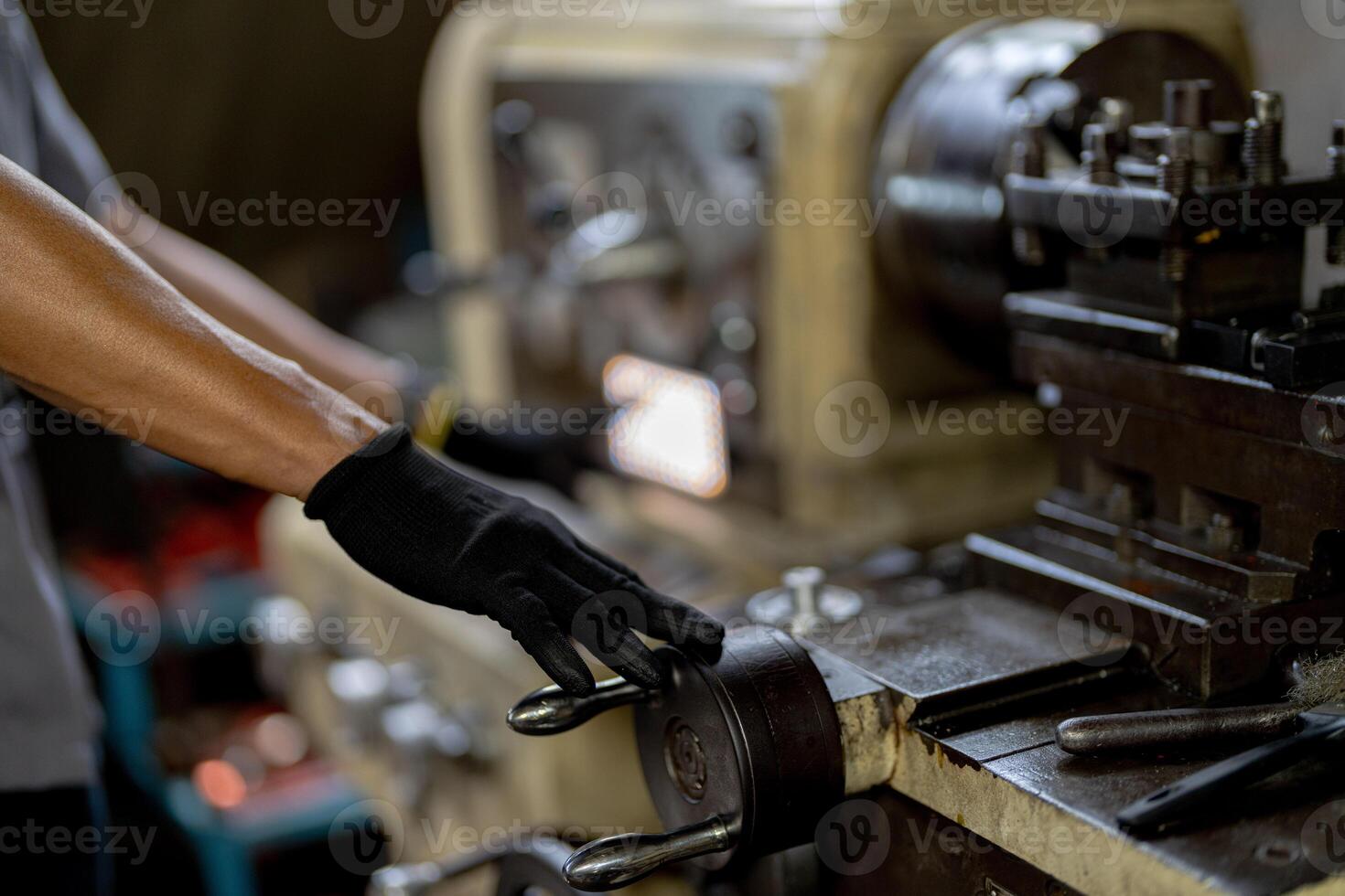 close up hand operation for Metal Lathes. steel column rolling in machine. metalworking industry. worker hand checks mechanic engine. Technician repairing drill bit on metal machine in factory photo