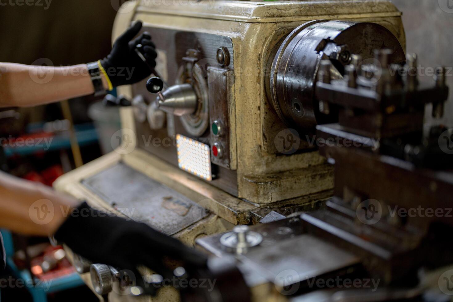 close up hand operation for Metal Lathes. steel column rolling in machine. metalworking industry. worker hand checks mechanic engine. Technician repairing drill bit on metal machine in factory photo