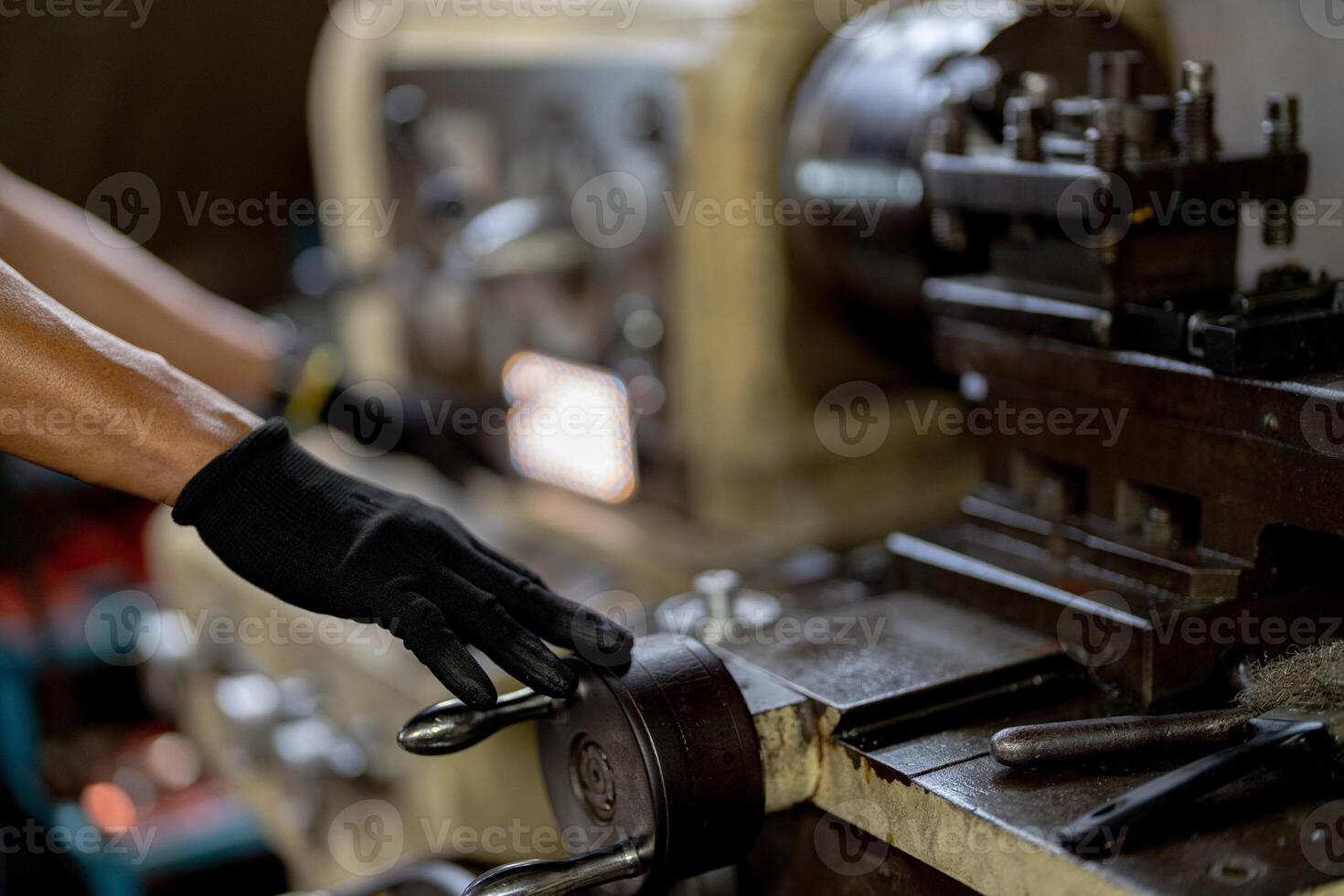 close up hand operation for Metal Lathes. steel column rolling in machine. metalworking industry. worker hand checks mechanic engine. Technician repairing drill bit on metal machine in factory photo