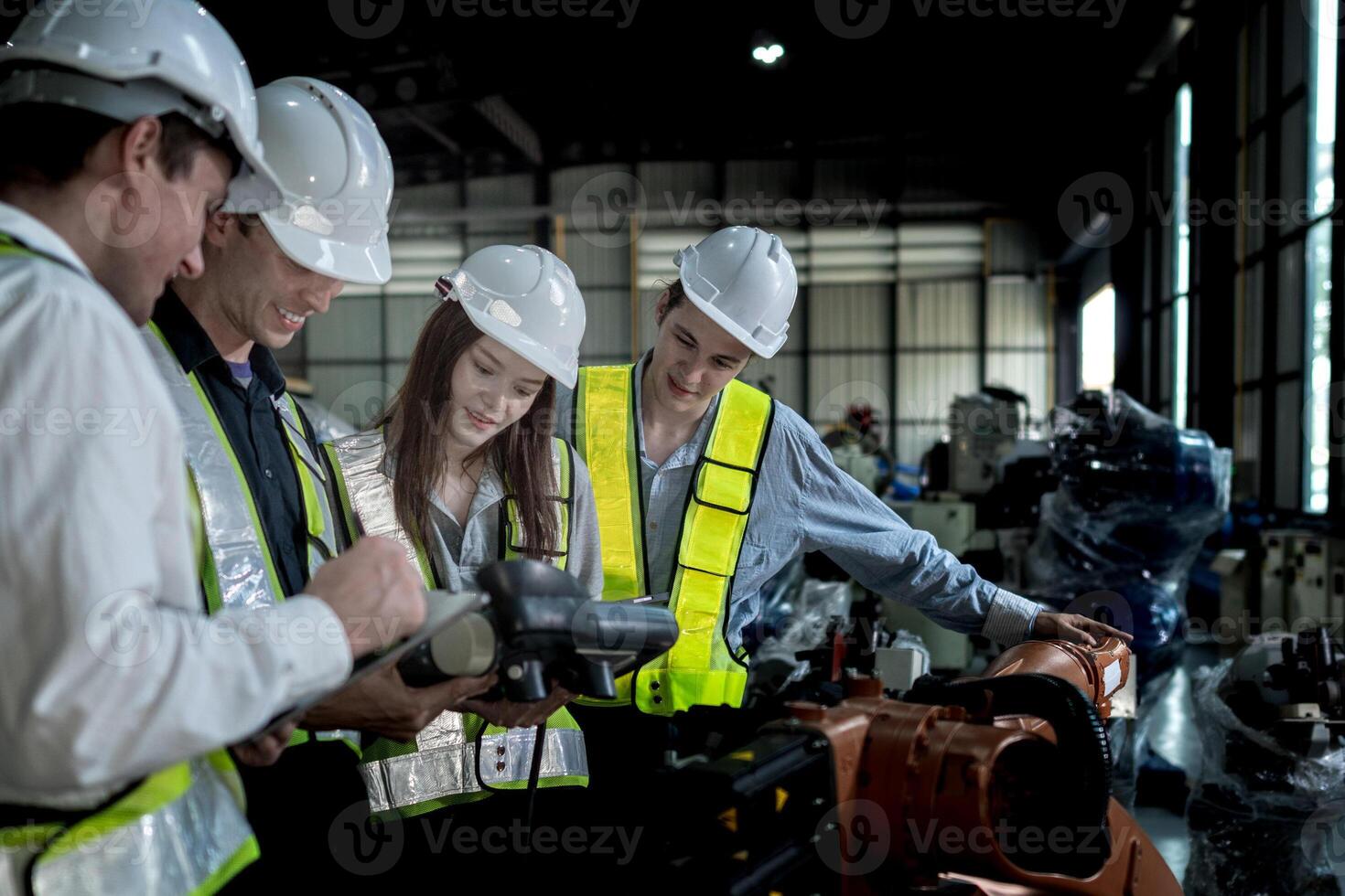 team engineers inspecting on machine with smart tablet. Worker works at heavy machine robot arm. The welding machine with a remote system in an industrial factory. Artificial intelligence concept. photo