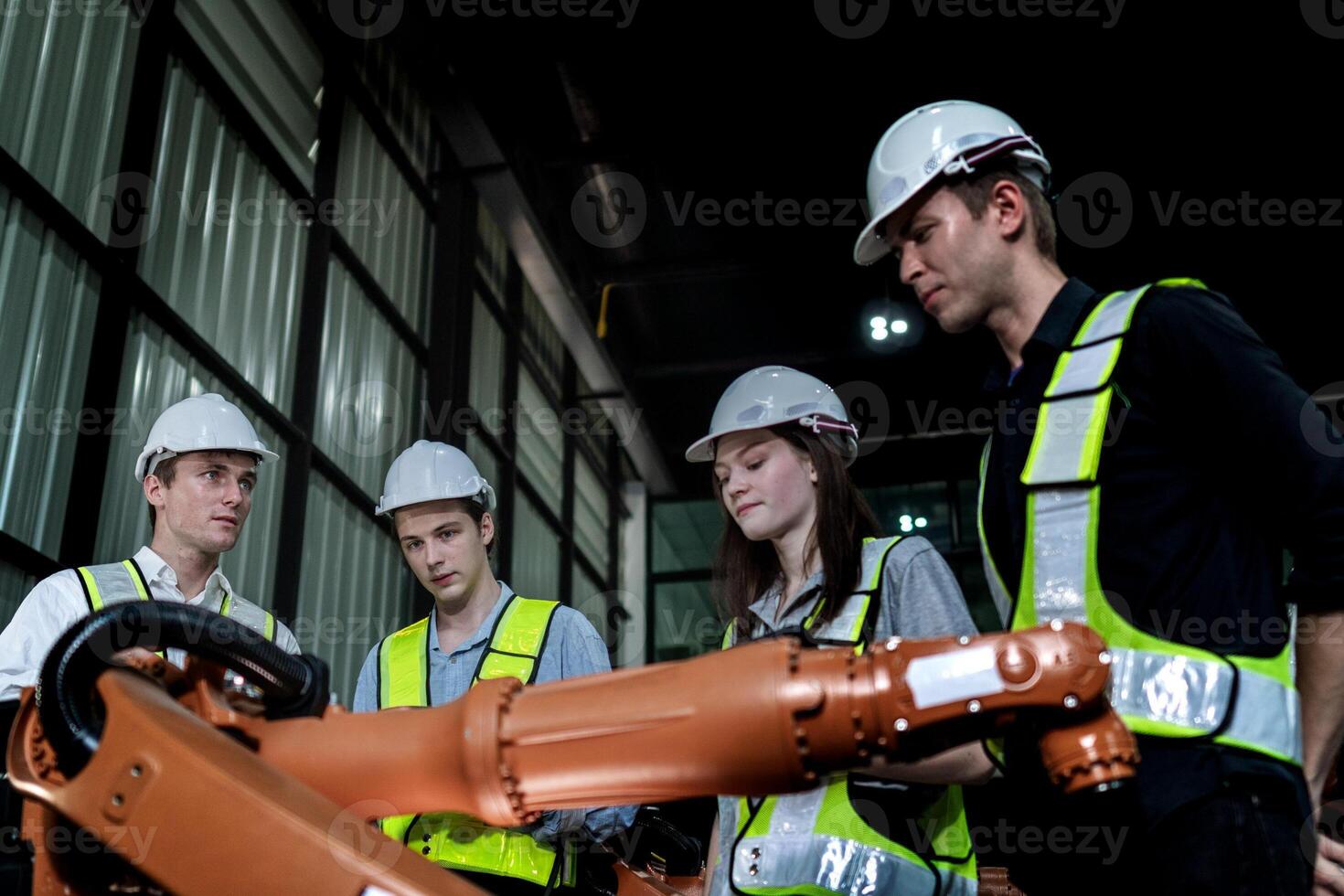 team engineers inspecting on machine with smart tablet. Worker works at heavy machine robot arm. The welding machine with a remote system in an industrial factory. Artificial intelligence concept. photo