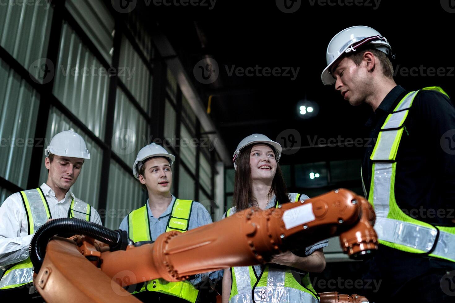 team engineers inspecting on machine with smart tablet. Worker works at heavy machine robot arm. The welding machine with a remote system in an industrial factory. Artificial intelligence concept. photo