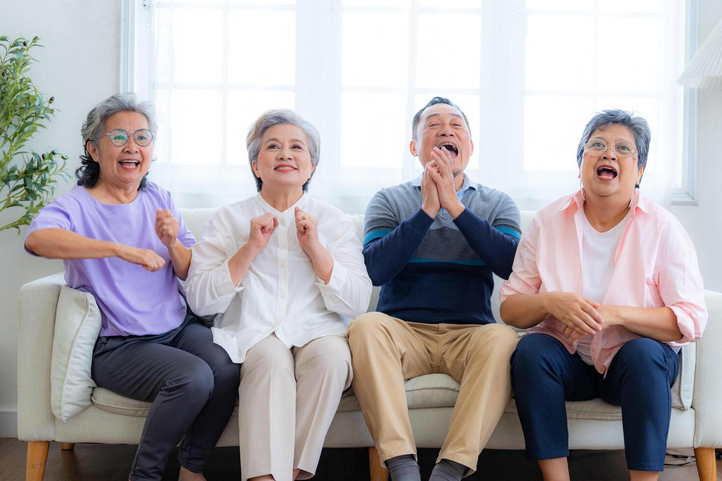 Happiness of the group females and male elderly sitting on the sofa. Senior people are talking and enjoy together at the living room. Joyful carefree retired senior friends enjoying relaxation. photo