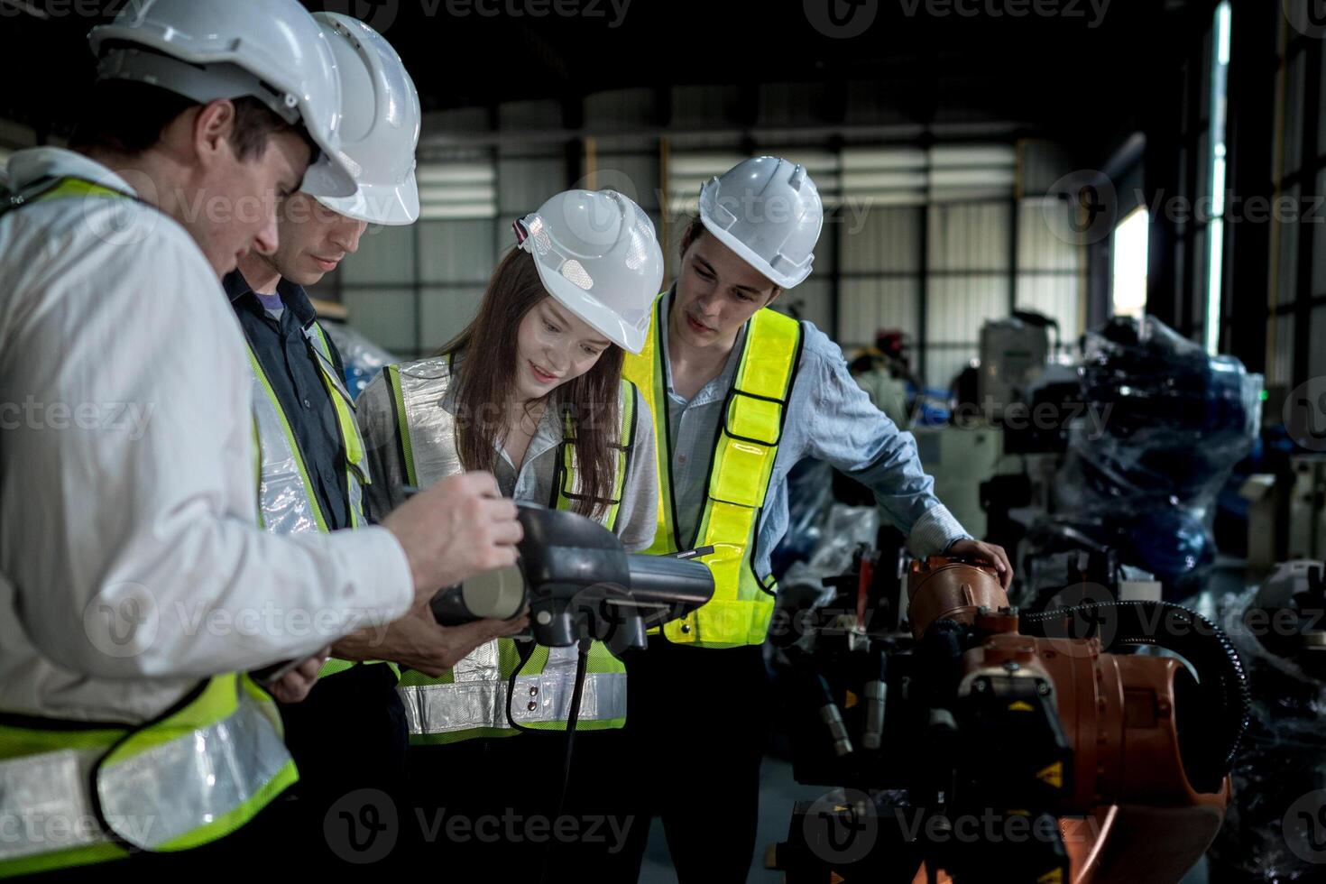 team engineers inspecting on machine with smart tablet. Worker works at heavy machine robot arm. The welding machine with a remote system in an industrial factory. Artificial intelligence concept. photo
