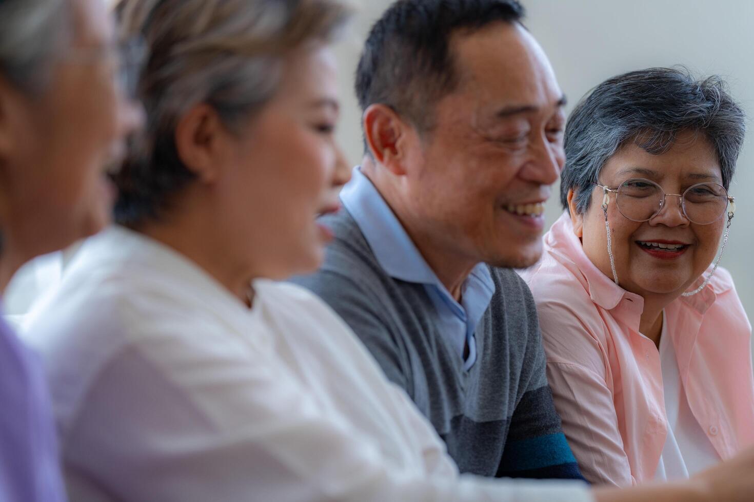 Happiness of the group females and male elderly talking with Call from smart tablet. Senior people are talking and enjoy together at the living room. Joyful retired friends enjoying relaxation. photo