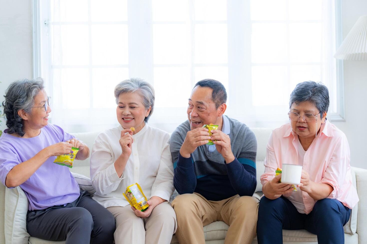 Happiness of the group females and male elderly sitting on the sofa. Senior people are talking and enjoy together at the living room. Joyful carefree retired senior friends enjoying relaxation. photo