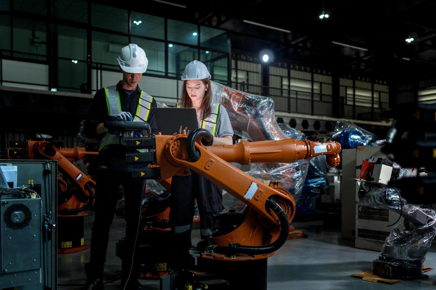 team engineers inspecting on machine with smart tablet. Worker works at heavy machine robot arm. The welding machine with a remote system in an industrial factory. Artificial intelligence concept. photo