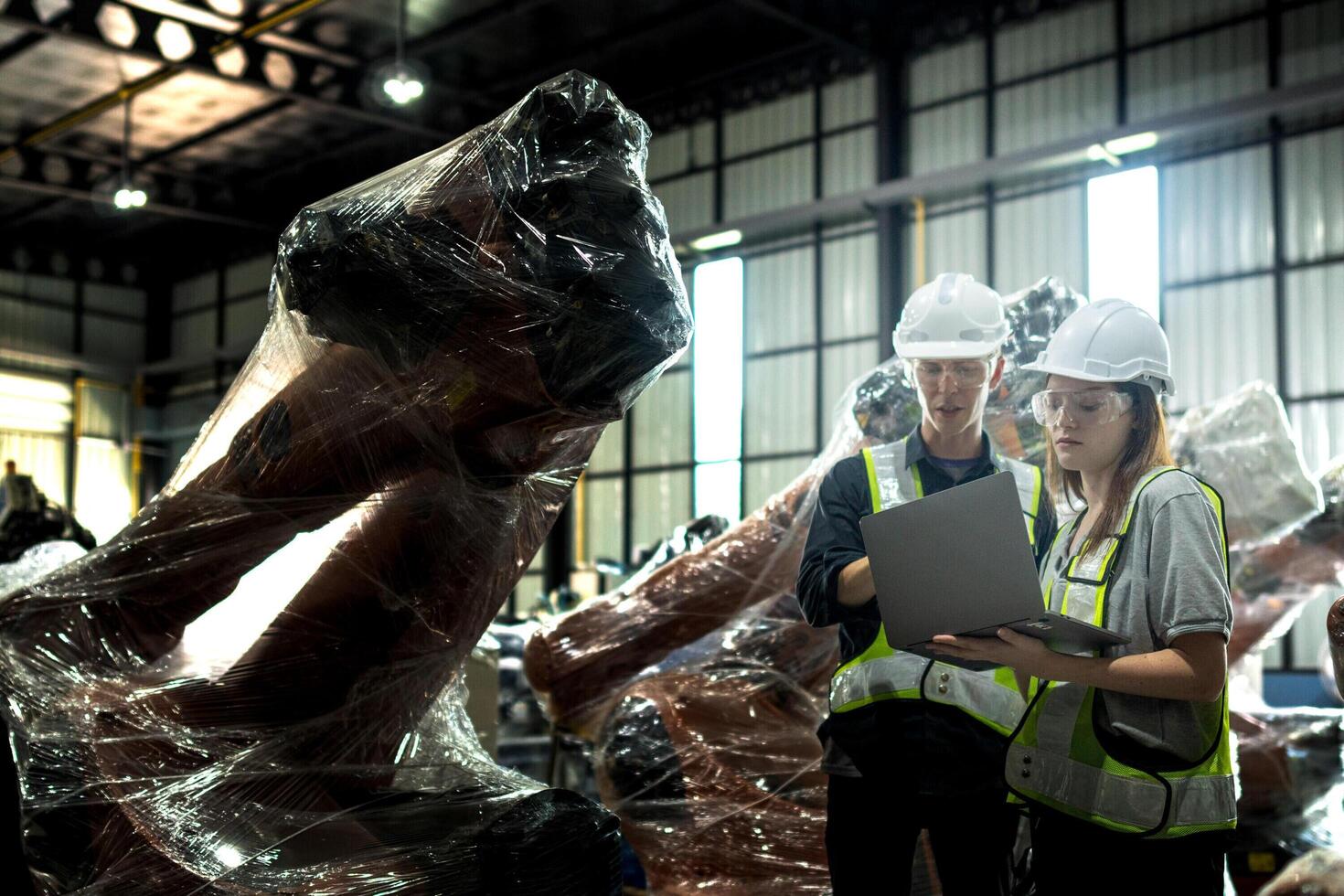 team engineers inspecting on machine with smart tablet. Worker works at heavy machine robot arm. The welding machine with a remote system in an industrial factory. Artificial intelligence concept. photo