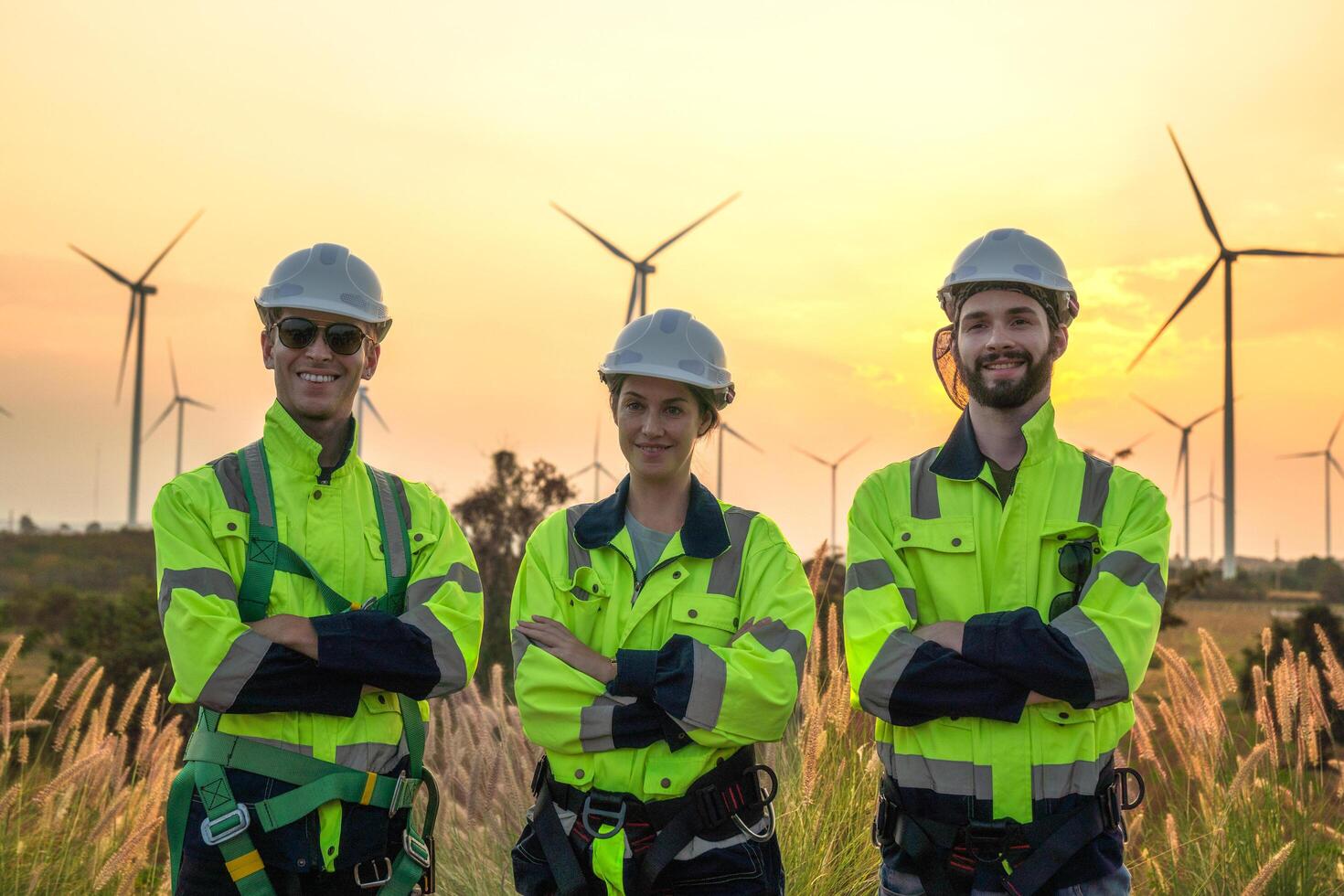 Team Engineers men and woman checking and inspecting on construction with sunset sky. people operation. Wind turbine for electrical of clean energy and environment. Industrial of sustainable. photo
