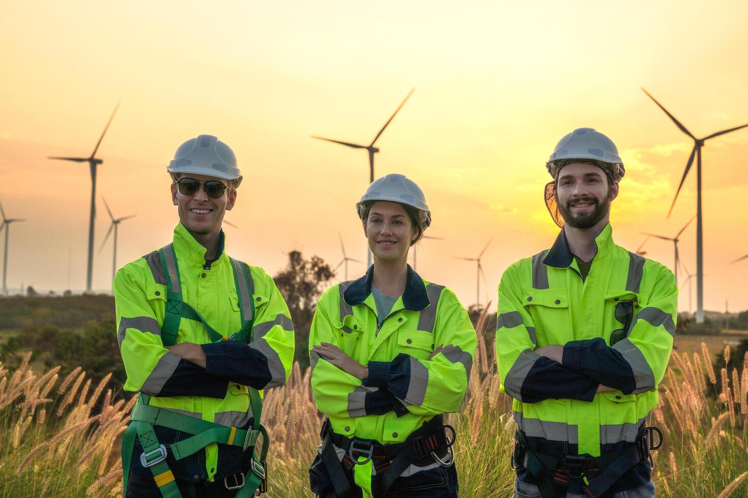 Team Engineers men and woman checking and inspecting on construction with sunset sky. people operation. Wind turbine for electrical of clean energy and environment. Industrial of sustainable. photo