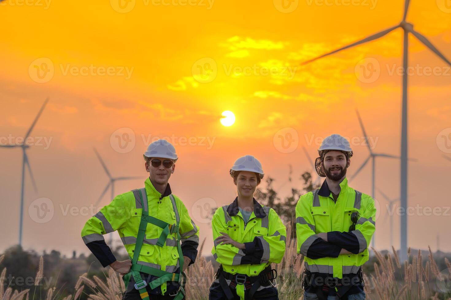 Team Engineers men and woman checking and inspecting on construction with sunset sky. people operation. Wind turbine for electrical of clean energy and environment. Industrial of sustainable. photo