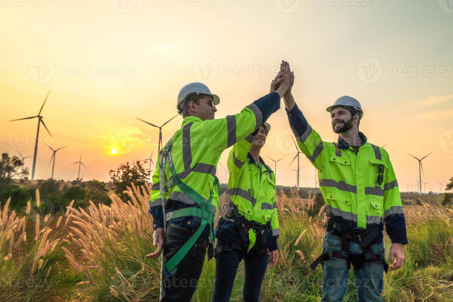 Team Engineers men and woman checking and inspecting on construction with sunset sky. people operation. Wind turbine for electrical of clean energy and environment. Industrial of sustainable. photo
