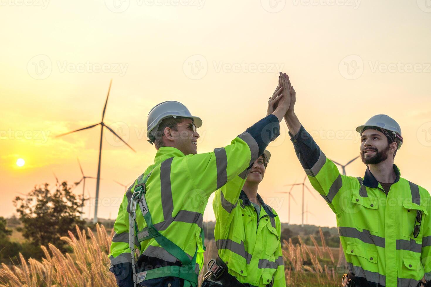 Team Engineers men and woman checking and inspecting on construction with sunset sky. people operation. Wind turbine for electrical of clean energy and environment. Industrial of sustainable. photo