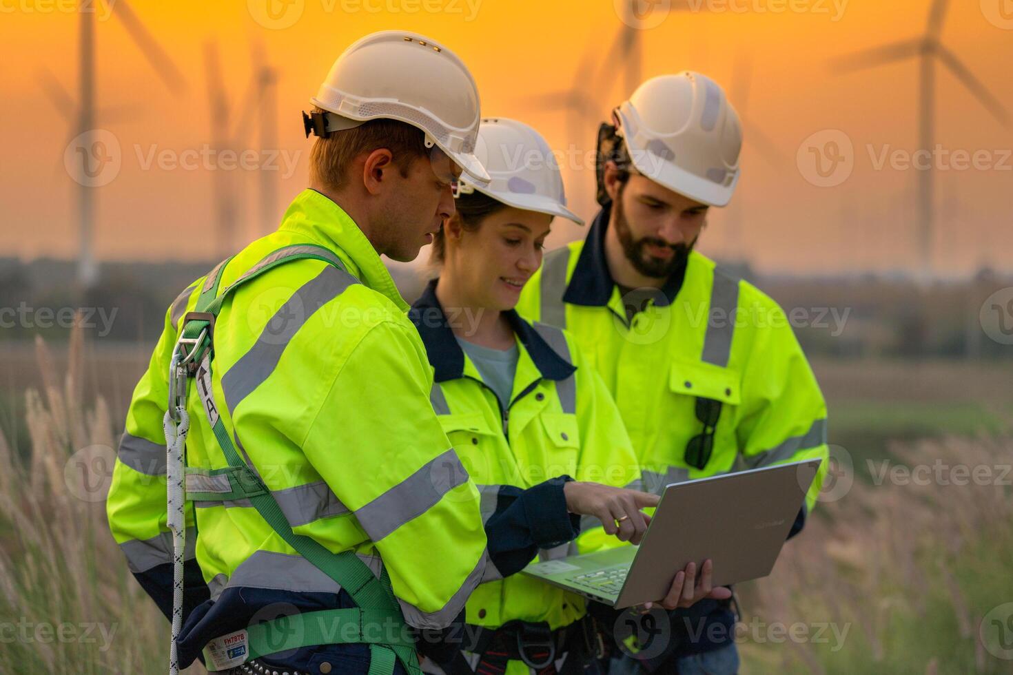 Team Engineers men and woman checking and inspecting on construction with sunset sky. people operation. Wind turbine for electrical of clean energy and environment. Industrial of sustainable. photo