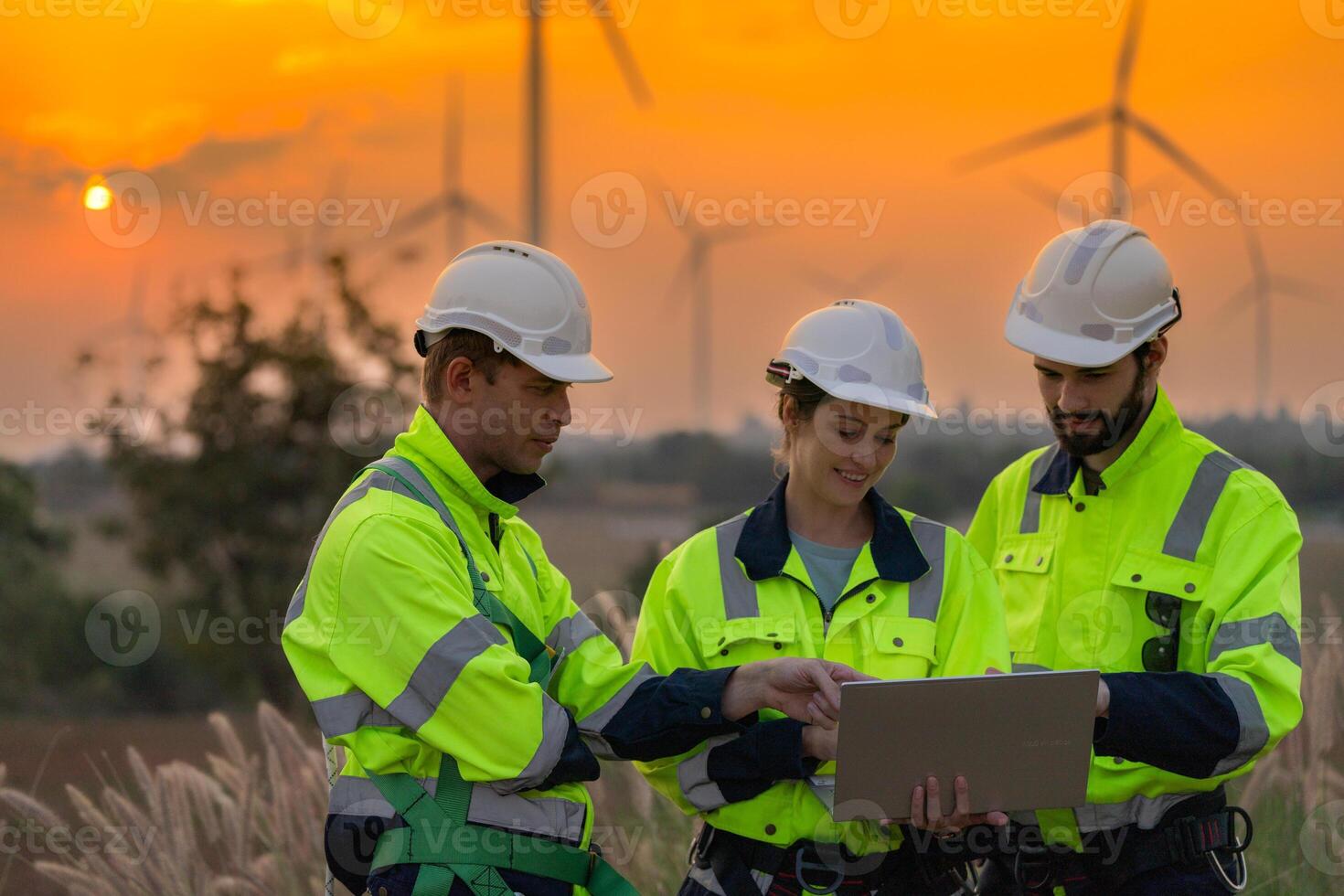 Team Engineers men and woman checking and inspecting on construction with sunset sky. people operation. Wind turbine for electrical of clean energy and environment. Industrial of sustainable. photo