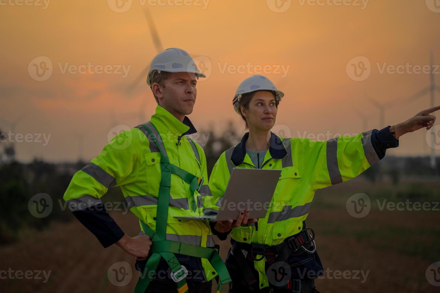 Team Engineers men and woman checking and inspecting on construction with sunset sky. people operation. Wind turbine for electrical of clean energy and environment. Industrial of sustainable. photo
