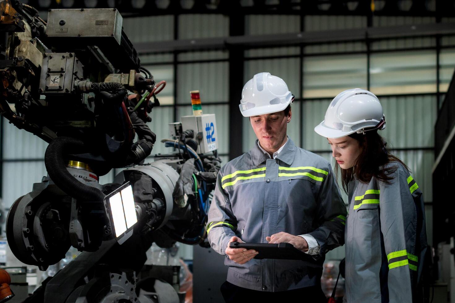 team engineers inspecting on machine with smart tablet. Worker works at heavy machine robot arm. The welding machine with a remote system in an industrial factory. Artificial intelligence concept. photo