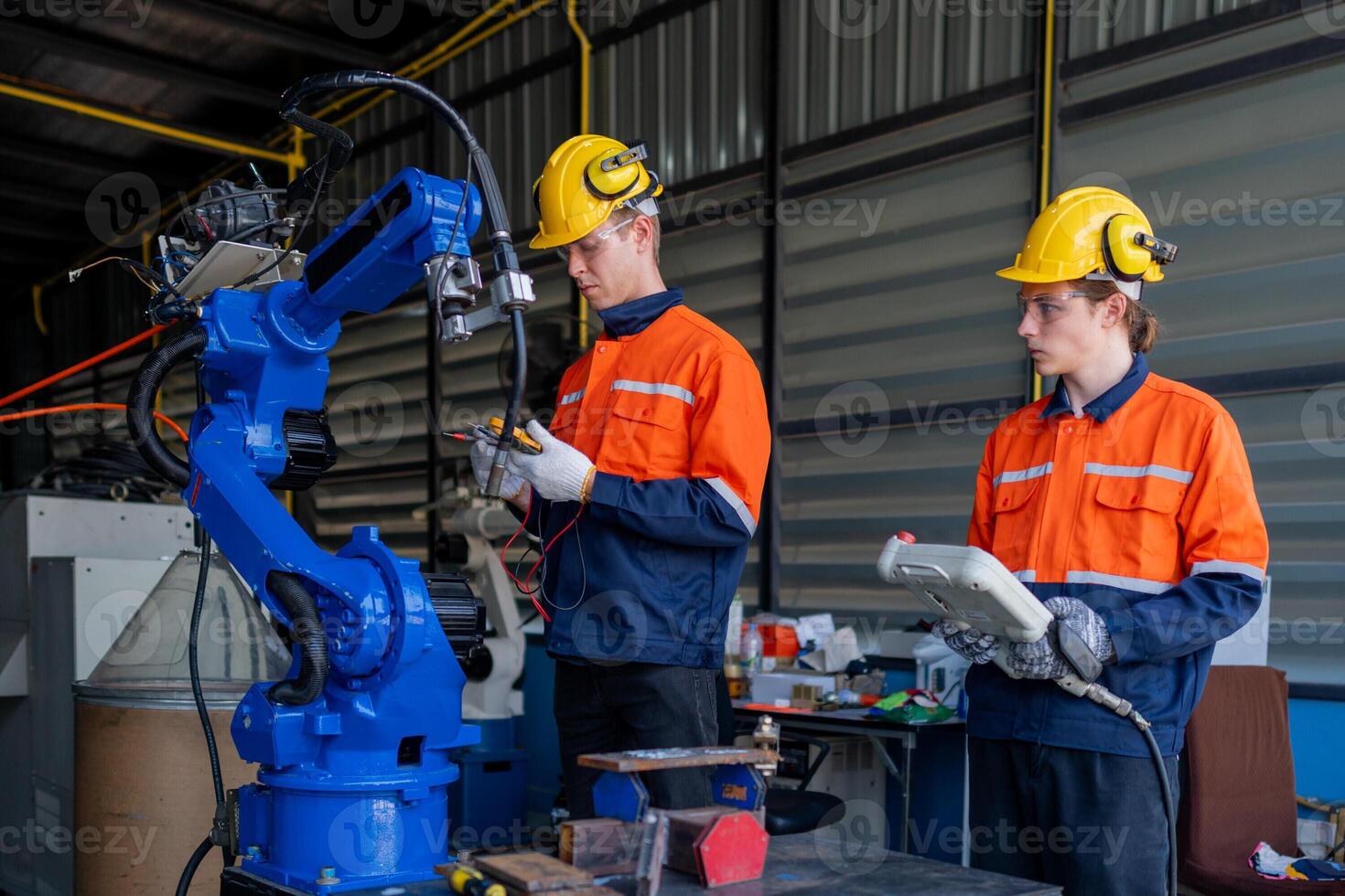 group of male engineer workers maintenance automatic robotic arm machine in a dark room factory. worker checking and repairing automatic robot hand machine. Worker wearing safety glasses and helmet. photo