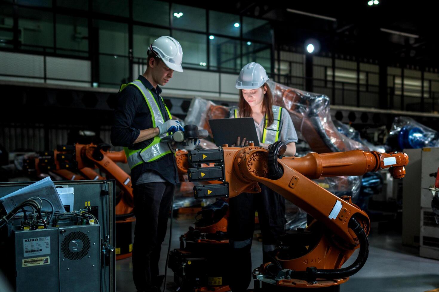 team engineers inspecting on machine with smart tablet. Worker works at heavy machine robot arm. The welding machine with a remote system in an industrial factory. Artificial intelligence concept. photo